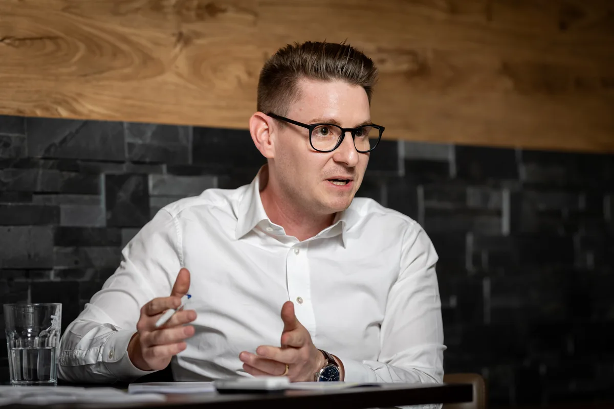 Für Lukas Schanz ist das neue Hallenbad ein «architektonischer Prunkbau». Ein Mann spricht und gestikuliert.